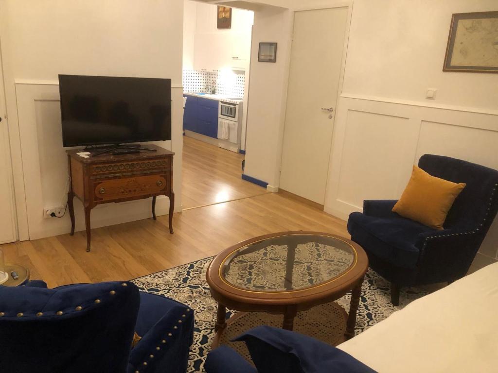 a living room with a tv and two chairs and a table at Captain’s Cabin Jakobstad Pietarsaari center in Pietarsaari