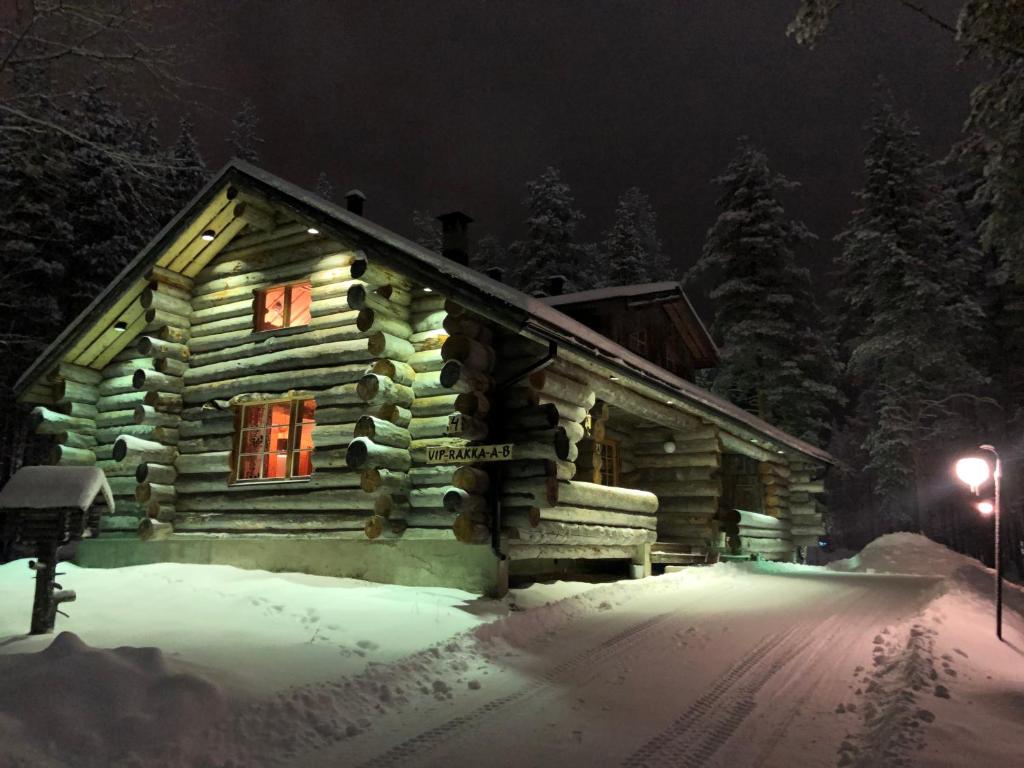 una cabaña de madera en la nieve por la noche en Levi Log Cabin - Viprakka 4A en Levi
