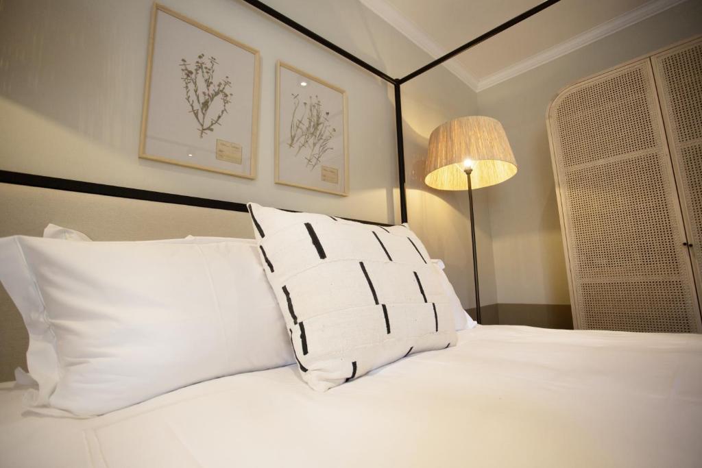 ウースターにあるBeckhuisのベッドルーム1室(白い枕とランプ付きのベッド1台付)