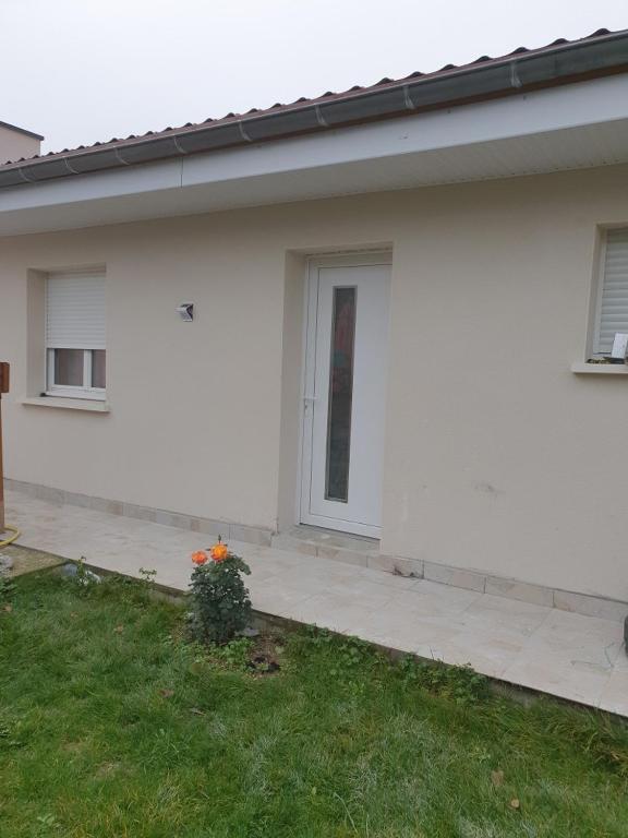 une maison blanche avec une porte et une cour dans l'établissement Eyssam d’or, à Dijon