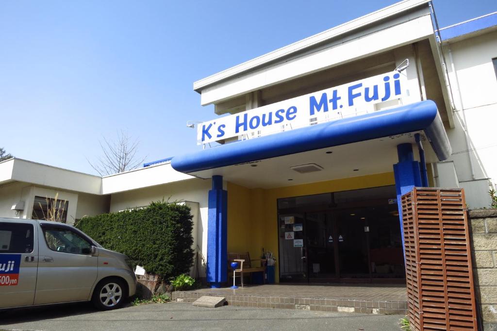 una furgoneta estacionada frente a un edificio de Kansas House Milt en K&#39;s House MtFuji -ケイズハウスMt富士- Travelers Hostel- Lake Kawaguchiko, en Fujikawaguchiko