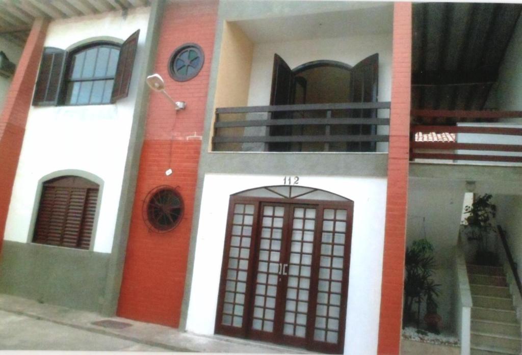 un edificio con una puerta y un reloj en él en Apartamento Iguaba Grande, bairro Canellas City , em frente ao trailer do popeye, en Iguaba Grande