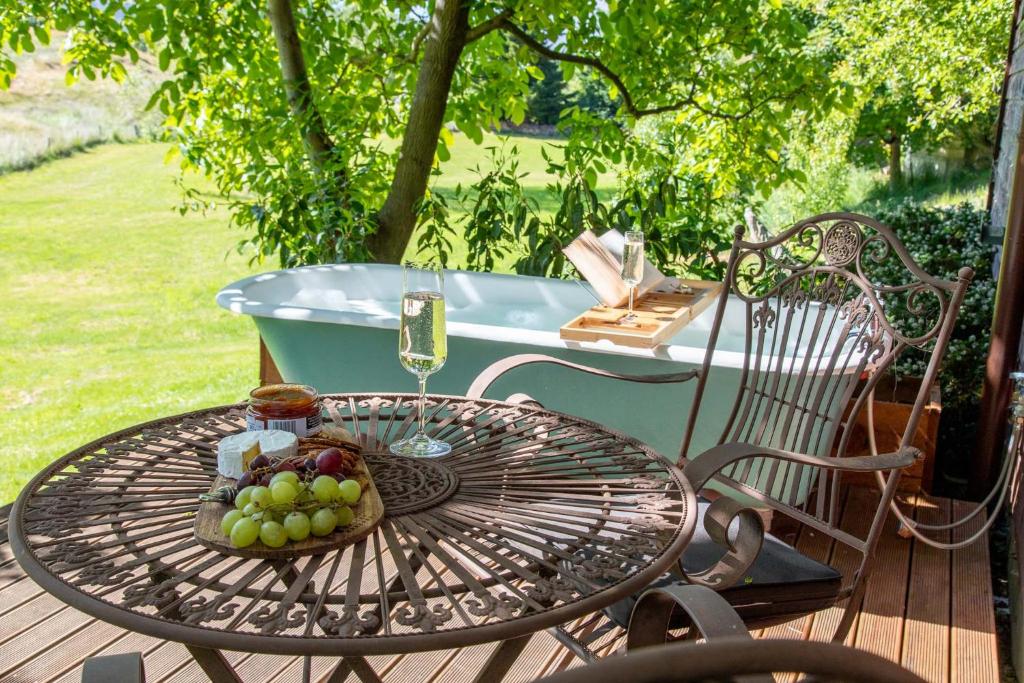 a table with a basket of grapes and a tub at Arrowtown Country Cottage in Arrowtown