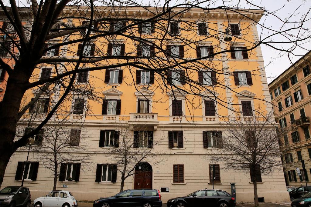 un grande edificio con macchine parcheggiate di fronte di 74 Crescenzio House a Roma