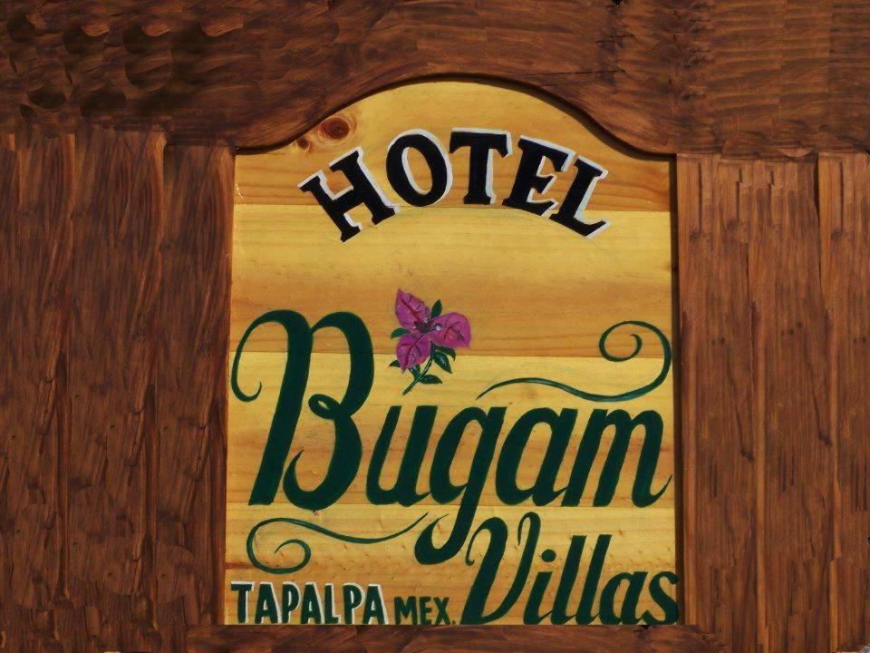 een bord voor een hotel in een houten muur bij Hotel Bugamvillas Tapalpa extensión in Tapalpa