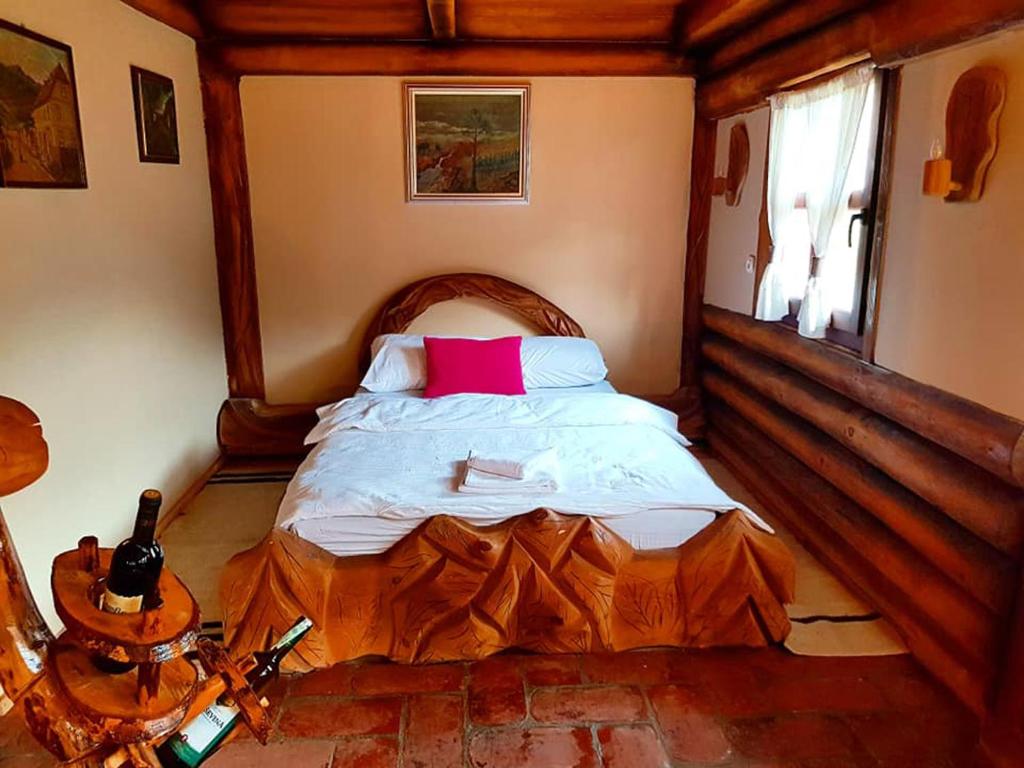 sypialnia z drewnianym łóżkiem i czerwoną poduszką w obiekcie Apartman Jahorina Dolina mira w mieście Pale
