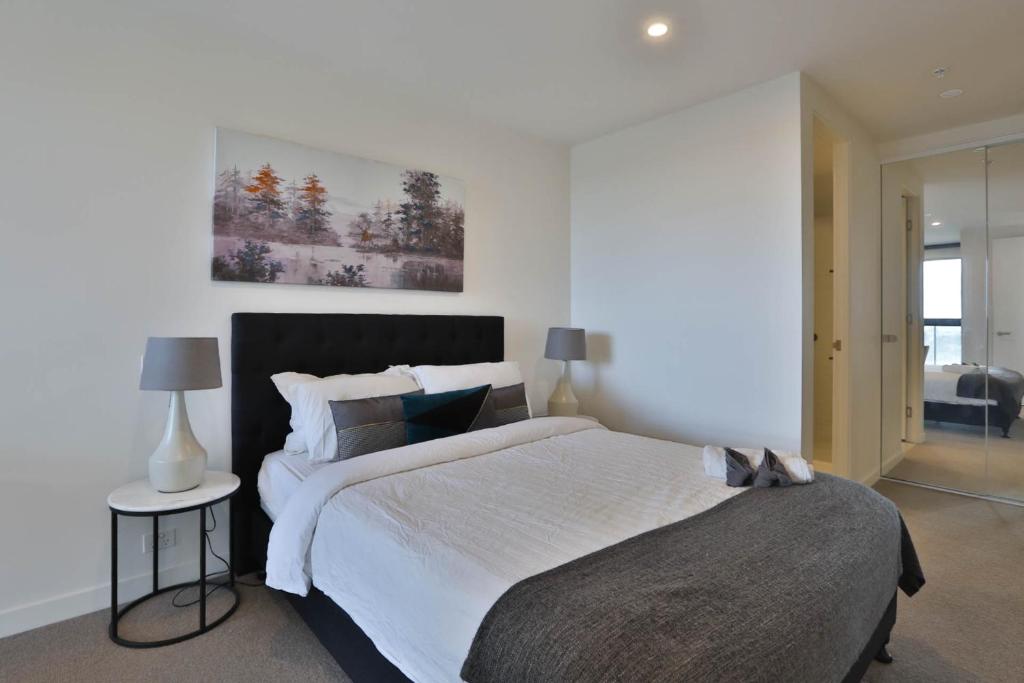 um quarto com uma cama grande num quarto em Next to 'The Glen Shopping Centre' Apartment em Glen Waverley