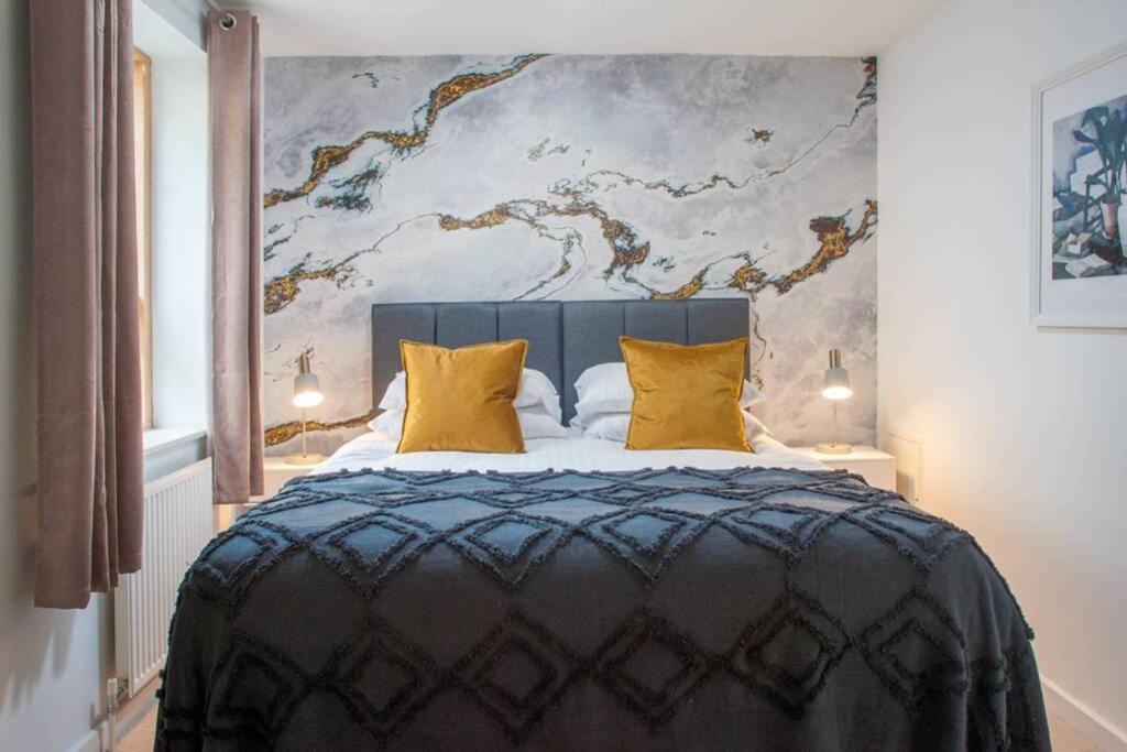 a bedroom with a large bed with yellow pillows at Clifton Jewel - 4 bed townhouse with parking. MyCityHaven in Bristol