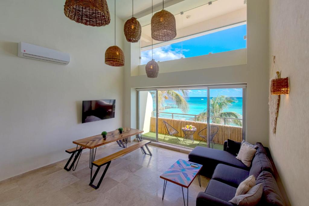 a living room with a couch and a table at Ocean Plaza by Zamá Homes in Playa del Carmen