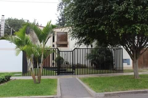 a black wrought iron fence in front of a house at Habitaciones en San Isidro in Lima