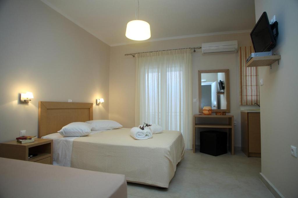 a hotel room with two beds and a television at Pantazis Studios in Nikiana