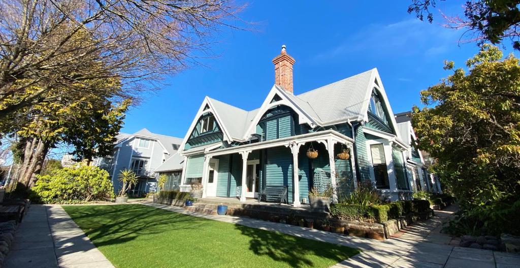 ein grünes Haus mit einem gemauerten Kamin oben in der Unterkunft Orari Boutique Hotel in Christchurch