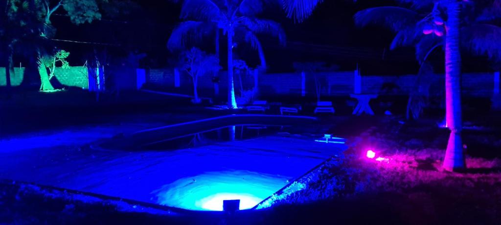 a swimming pool at night with blue and purple lights at Gran Luha Motel, Hotel e Chalés in Brotas