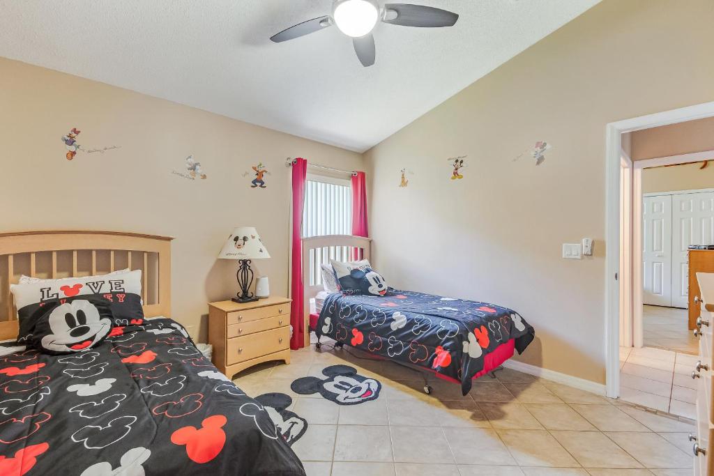 sypialnia z 2 łóżkami i wentylatorem sufitowym w obiekcie Two Master Bedrooms Pool Home Private Yard w Orlando