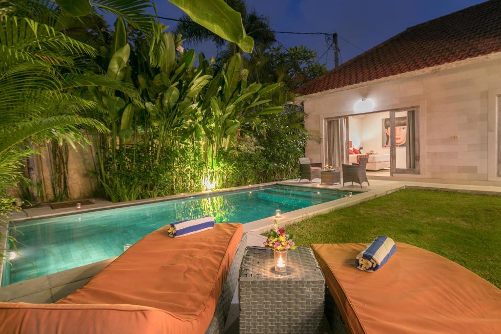 a backyard with a swimming pool and a house at Villa Briana Seminyak by Bali Villas R Us in Seminyak