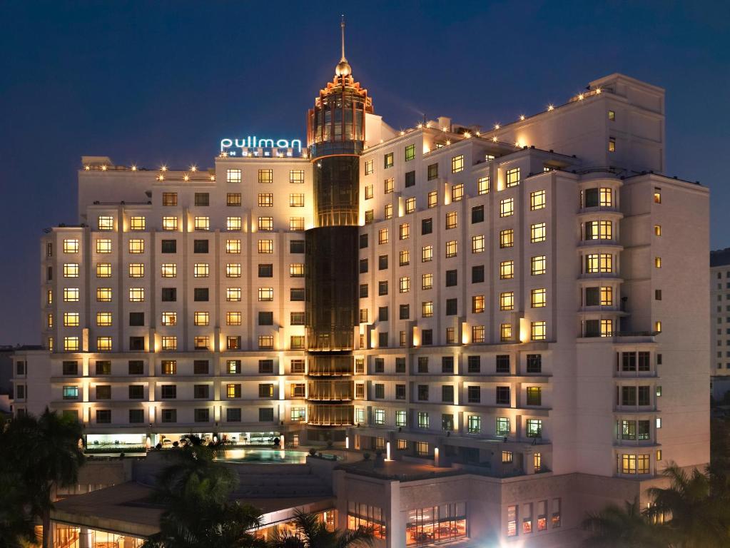 a large building with a clock tower at night at Pullman Hanoi in Hanoi