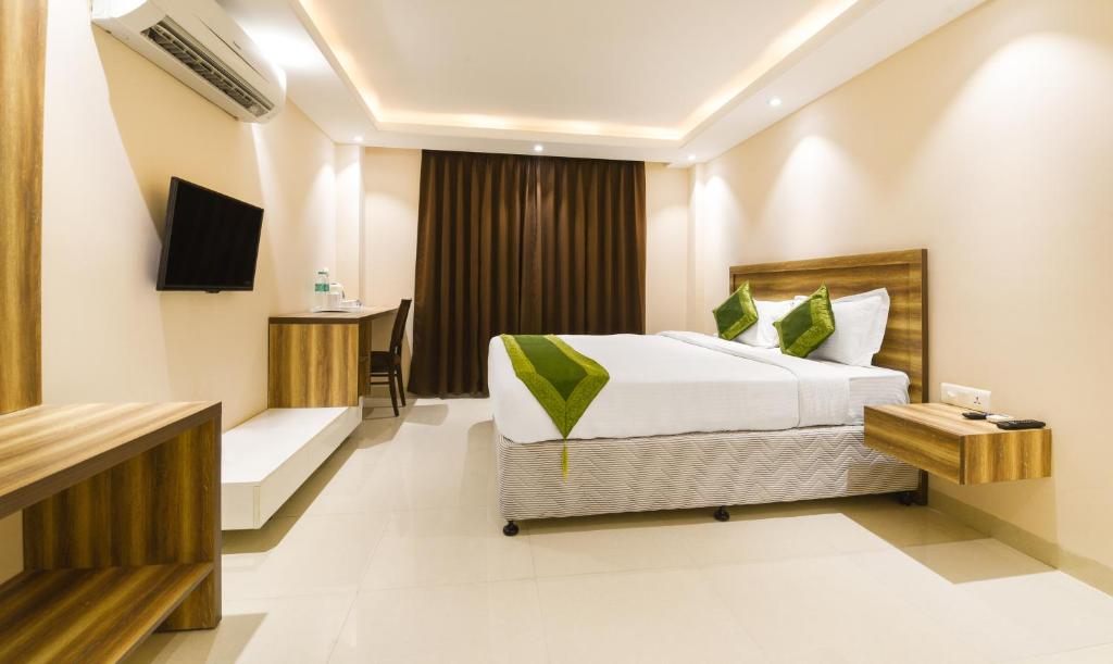 Pokój hotelowy z łóżkiem i biurkiem w obiekcie Treebo Trend Iffco Chowk w mieście Gurgaon