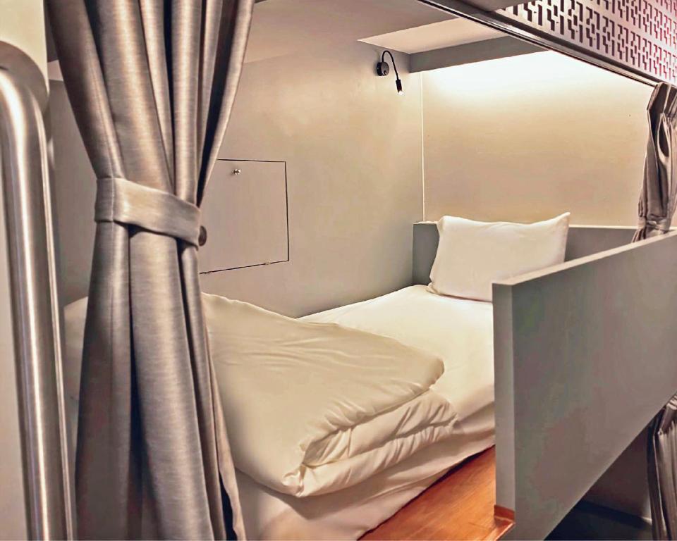 uma cama num quarto com uma cortina em Capzule Bed Phuket em Phuket