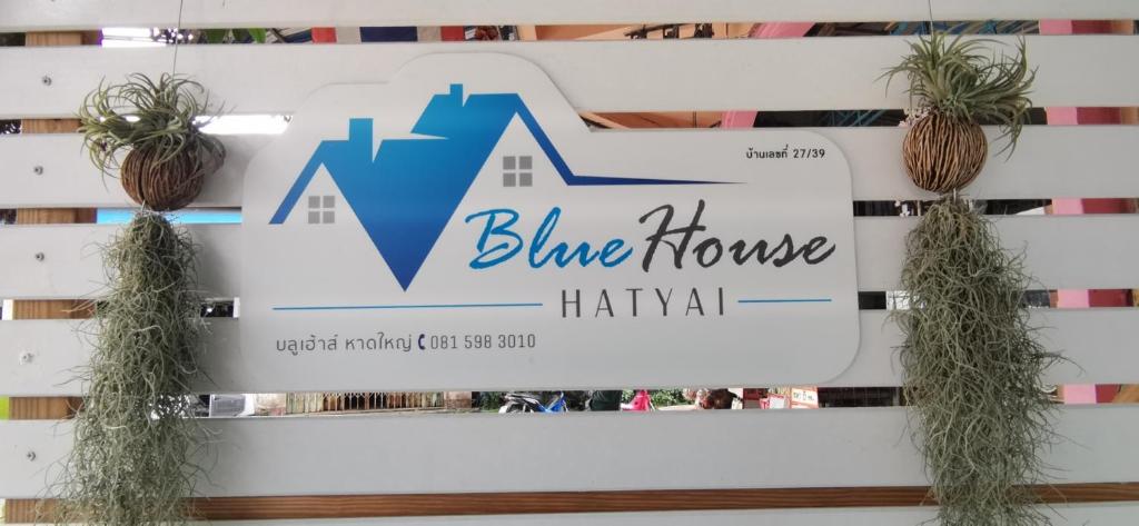 una señal para la casa azul con dos plantas en Blue House Hat Yai en Hat Yai
