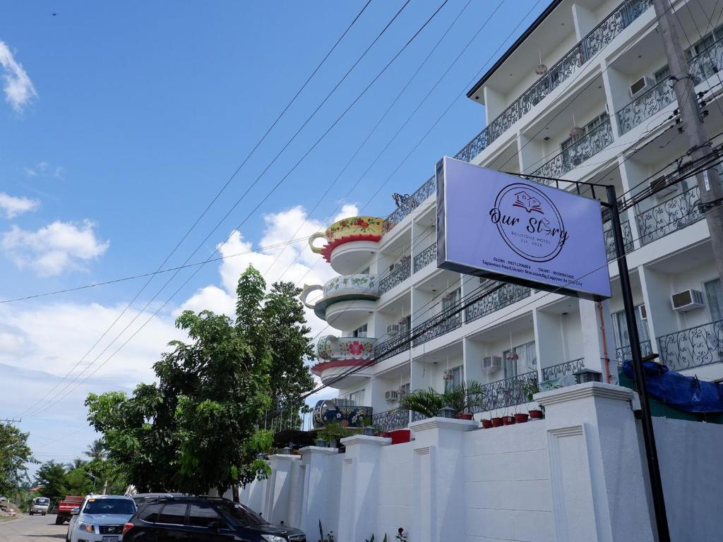 a white building with a sign in front of it at Our Story Boutique Hotel in Cagayan de Oro