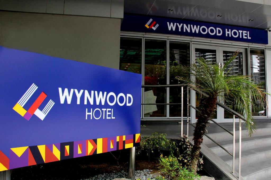 una señal de hotel de Wynwood frente a un edificio en Wynwood Hotel en Manila