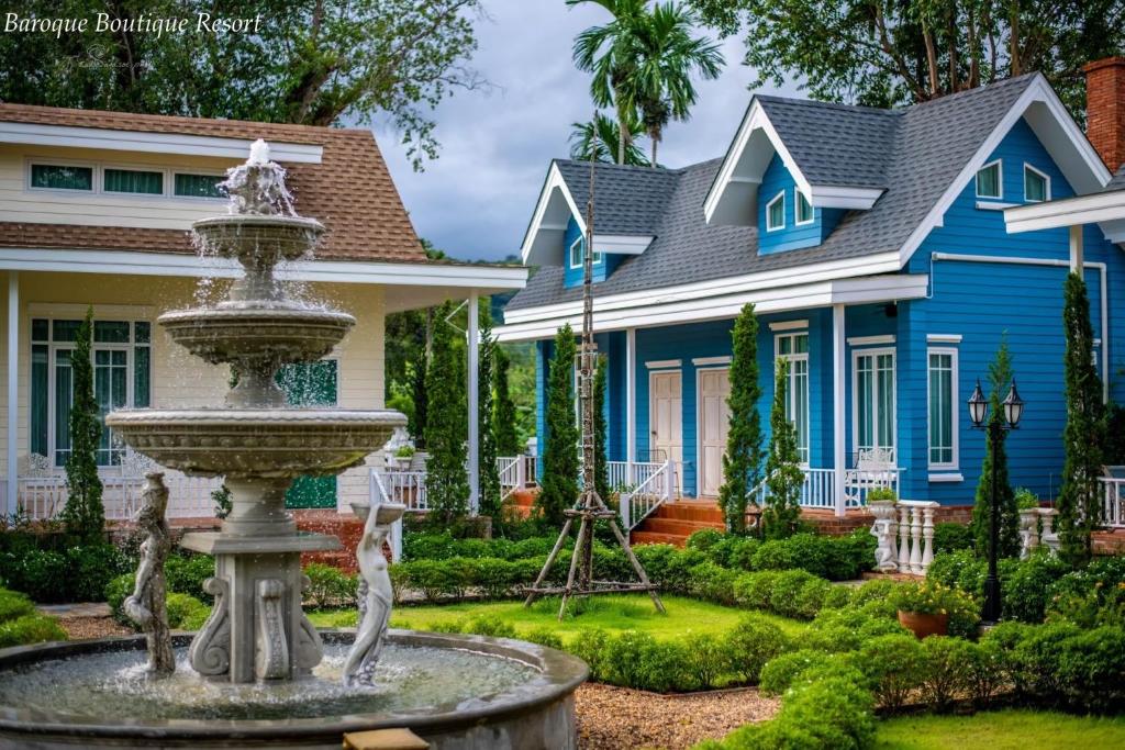 una casa azul con una fuente frente a una casa en Baroque Boutique Resort, en Ranong