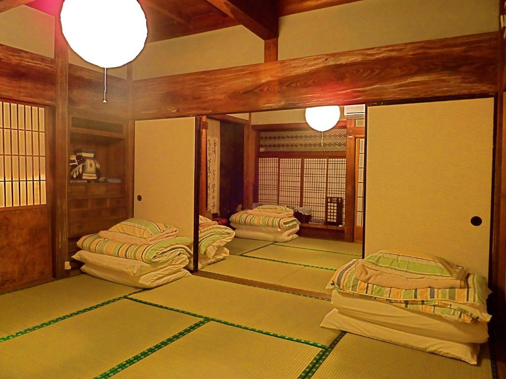 a room with two beds and a mirror at Kominka Sharehouse Hooju in Miyazaki