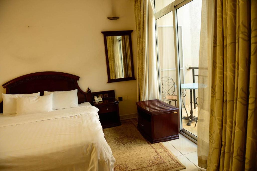 een slaapkamer met een bed en een glazen schuifdeur bij Room in Apartment - This Standard Suite offers a brilliant experience with the amenities offered in Kigali