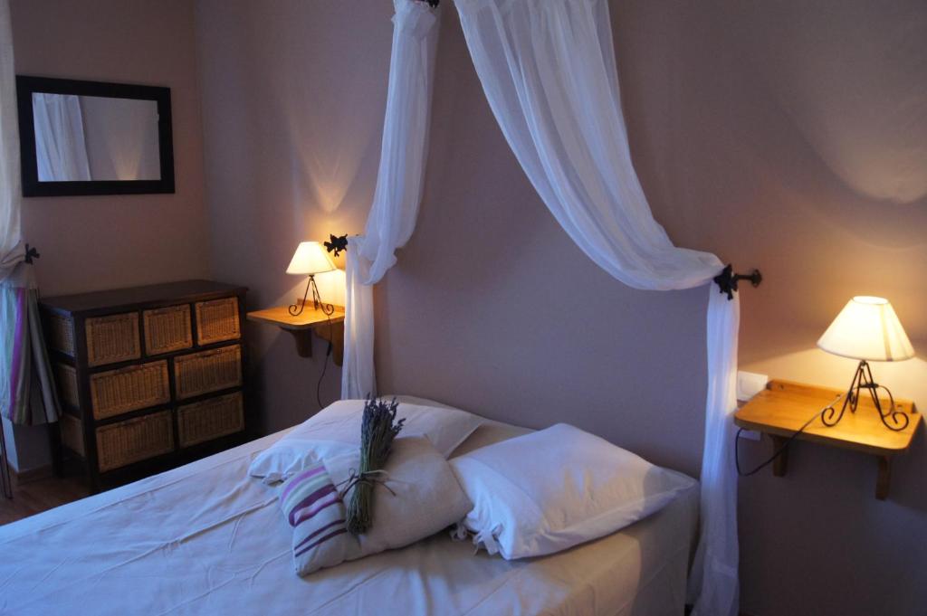 a bedroom with a white bed with two lamps at La Clavelière in Saint-Auban-sur-Ouvèze