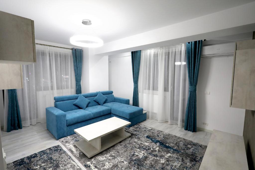 a living room with a blue couch and a table at SIF Residence in Craiova