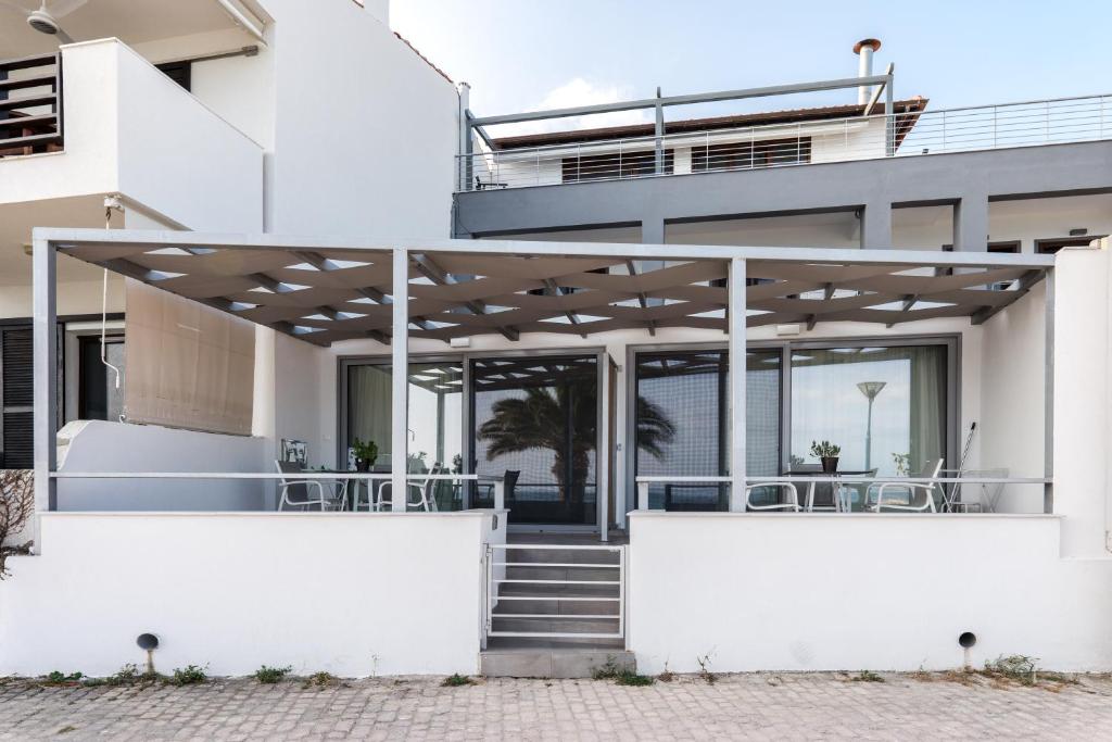 a white house with a staircase leading up to it at Mougre studios in Polychrono