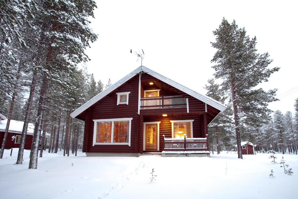 eine Blockhütte im Wald im Schnee in der Unterkunft Levi President Välirakka Chalet in Levi