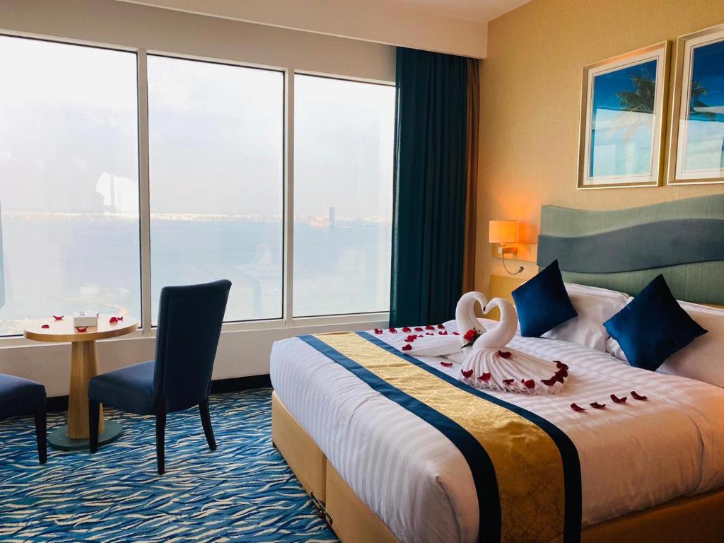 a hotel room with a bed with a swan on it at Harbour Suites Hotel in Manama