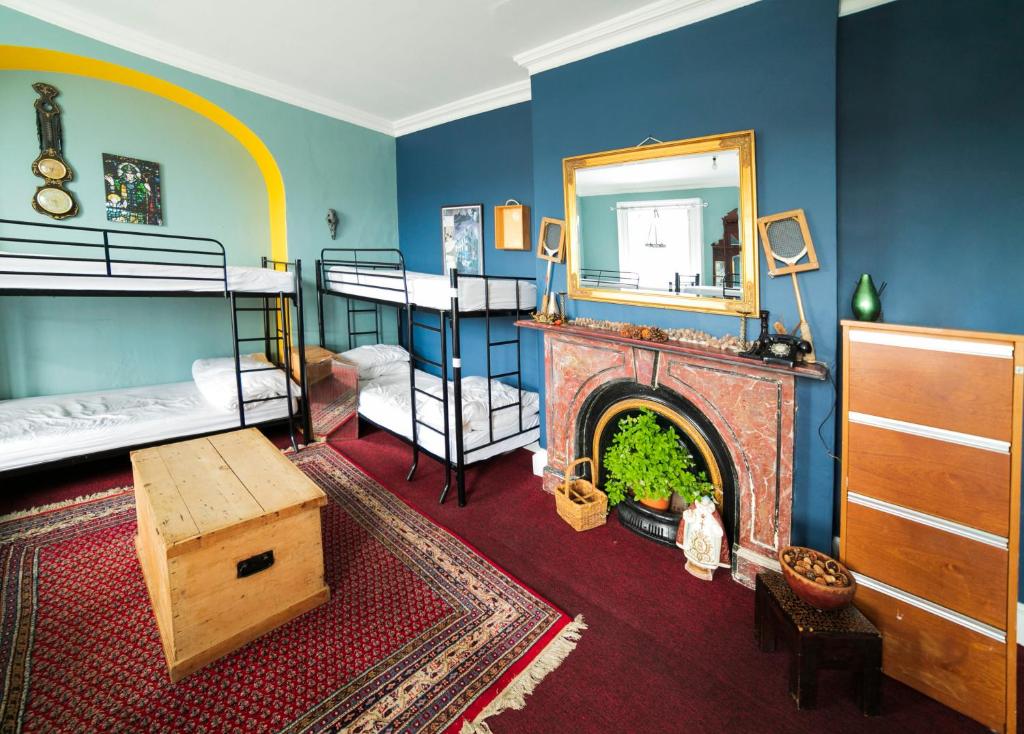 a room with a fireplace and a bedroom with bunk beds at Spoon and the Stars Hostel in Drogheda