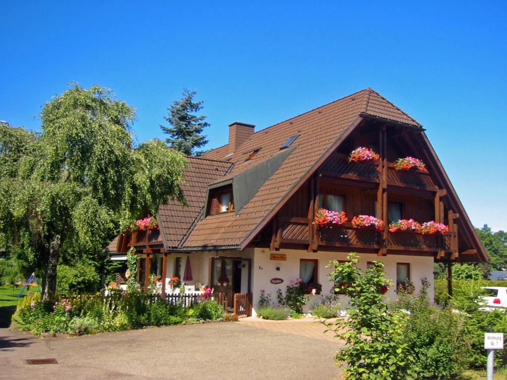 a house with flower boxes on the front of it at Ferienhaus im Park in Hinterzarten