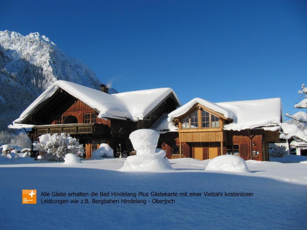una casa cubierta de nieve delante en Haus Pfannenhölzer, en Bad Hindelang