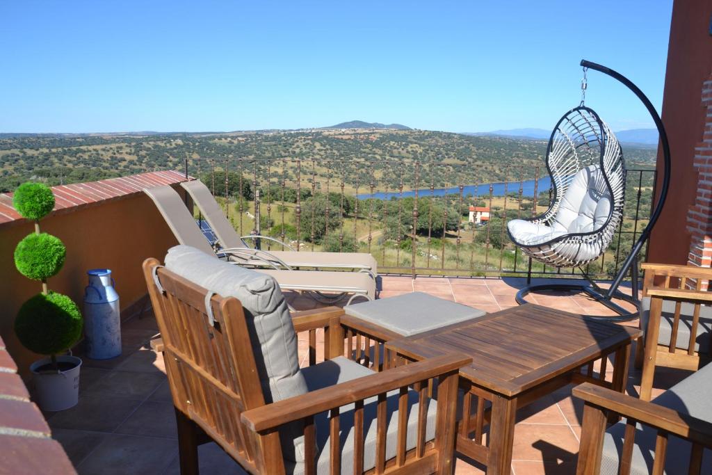 a patio with a table and chairs on a balcony at Casa Rural & SPA Mirador Gredos in Guijo de Ávila