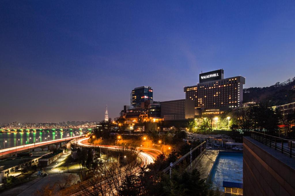 a city street at night with a large building at Grand Walkerhill Seoul in Seoul