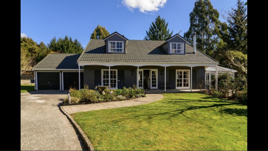 a house with a green lawn in front of it at Amy's Forest City Villa in Rotorua