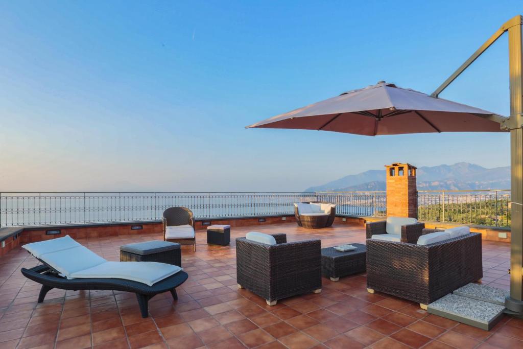 a patio with chairs and an umbrella on a roof at Casa Spartano in Sorrento