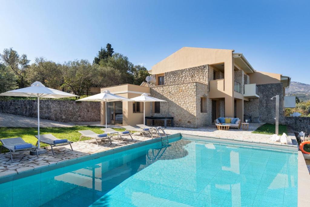 uma villa com uma piscina e uma casa em Villa Pietra Gialla by Rodostamo Collection em Kassiopi