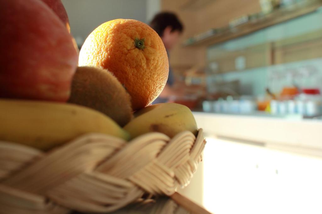 a basket filled with oranges and bananas on a counter at Alma di Alghero Hotel in Alghero