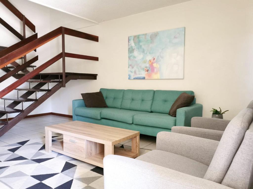 a living room with a blue couch and a table at Palm Waters Holiday Villas in Townsville