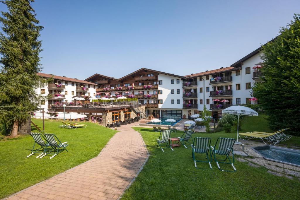 a group of chairs and umbrellas in a park at Hotel Kroneck in Kirchberg in Tirol
