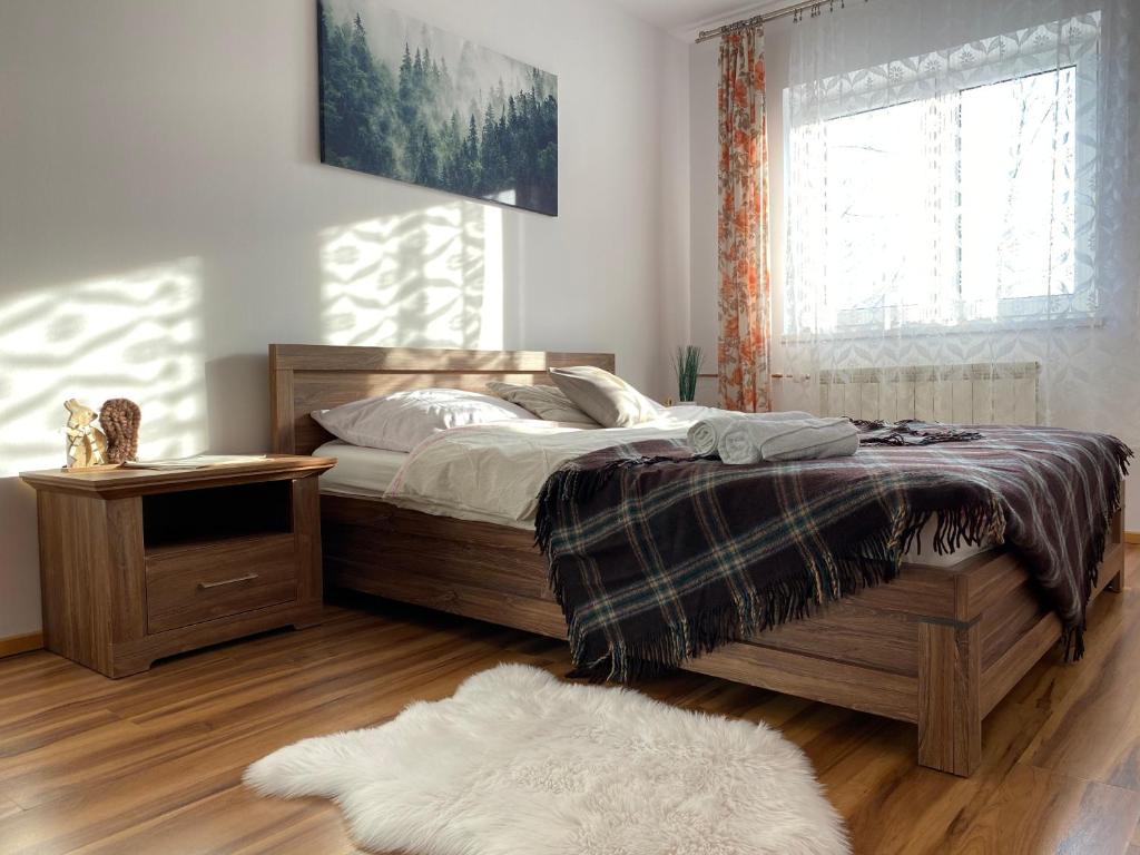 1 dormitorio con cama, ventana y alfombra en Pokoje Gościnne Pod Jaworem en Białka Tatrzanska