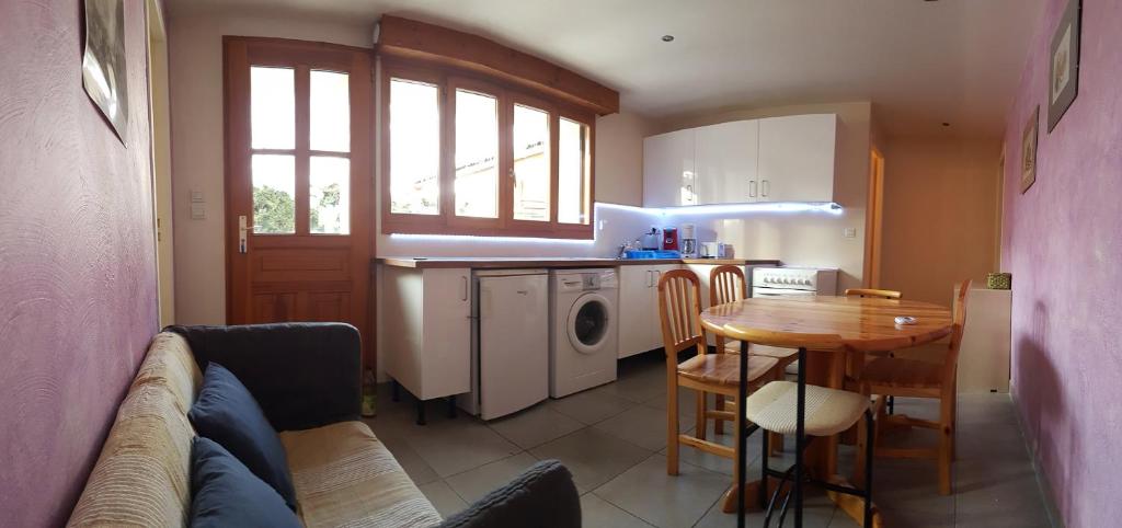 a kitchen with a couch and a table in a room at Au Coeur Des Ecrins in LʼArgentière-la-Bessée