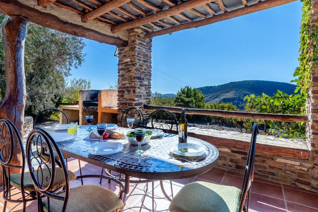 patio con mesa y sillas en el balcón en Cortijo la Loma de la Alpujarra en Pitres