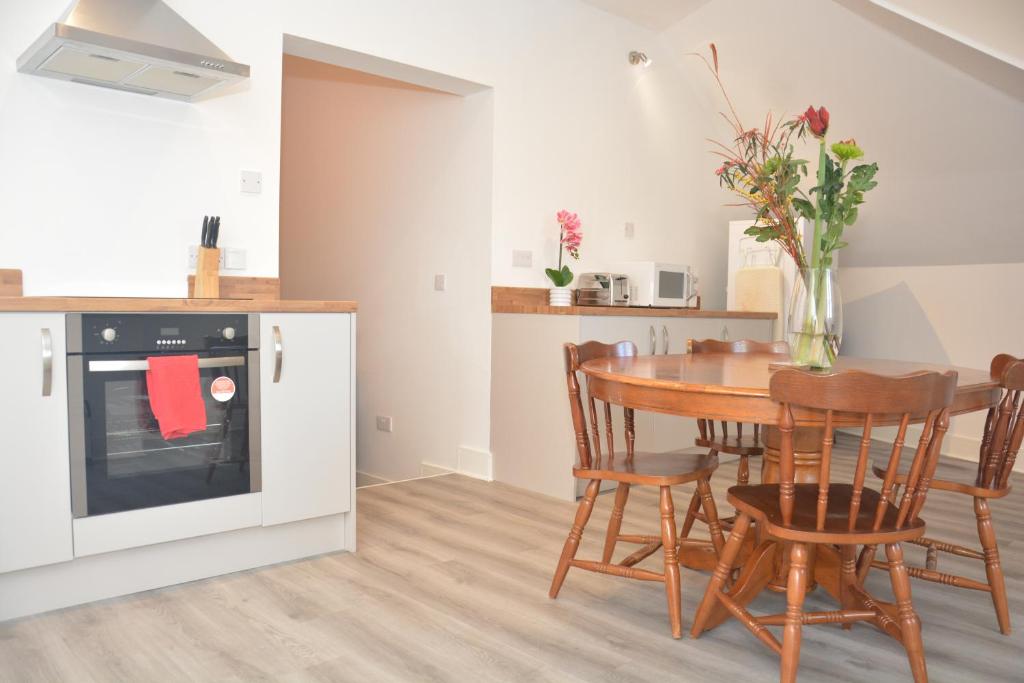 a kitchen and dining room with a table and chairs at Apartment 4 Biddicks Court in St Austell