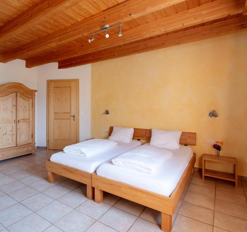 two beds in a room with a wooden ceiling at Hotel Frohe Aussicht in Uznach