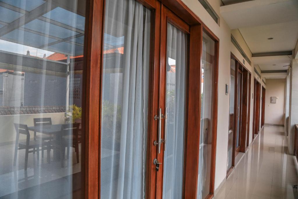 a hallway with sliding glass doors and a table at Alia Home in Sanur